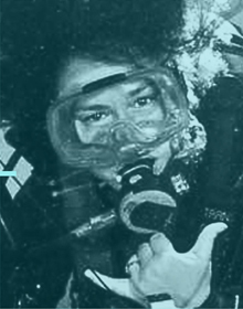 Woman diver underwater giving the Shaka hand sign