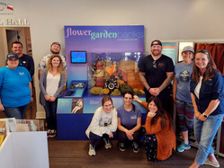 Sanctuary staff gathered around a Flower Garden Banks exhibit with corals, dive gear, and a looping video