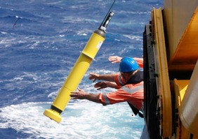 Man throwing ARGO buoy overboard into ocean