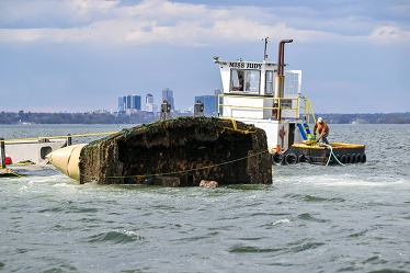 People removing a sunken vessel from a waterway.