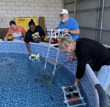 People putting ROVs in a pool.