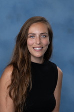Breanna Vanderplow headshot, dark blond long hair, blue eyes, sleeveless black shirt