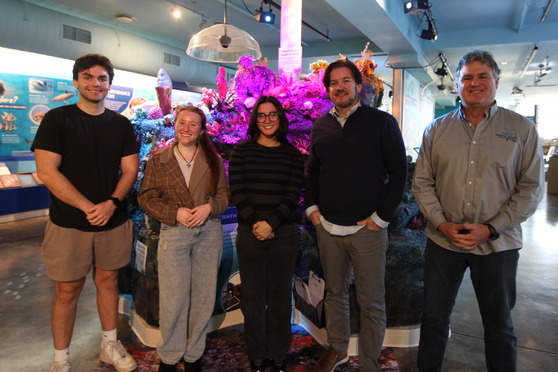 People standing in front of a life-like reef model.