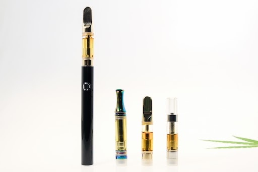 A reusable e-cigarette battery next to the replaceable (single-use) cartridges. 