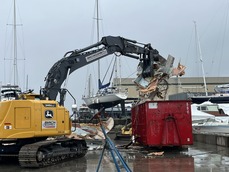 An excavator being used to break down a derelict vessel.