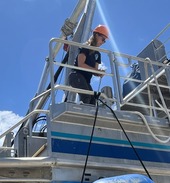 People in helmets standing near a boat.