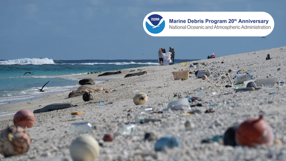 A sandy shoreline is littered with various types of plastic debris. 