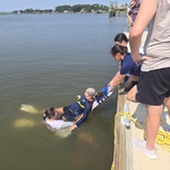 In-water rescue of a person on a backboard in Skidaway River. 