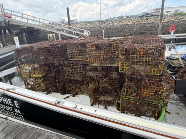 A stack of derelict lobster traps stacked on top of one another on a vessel.