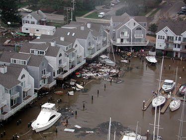 Large amounts of vessel and property damage around a flooded marina. 