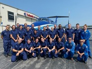 NOAA Corps officer cadets and pilots in blue with a Twin Otter aircraft