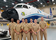 A group of NOAA Corps officers standing in front of a NOAA WP-3D Orion aircraft