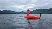 A bright orange uncrewed surface vehicle known as the DriX on the water