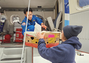 ENS Cheng loads cold stunned turtles onto Twin Otter