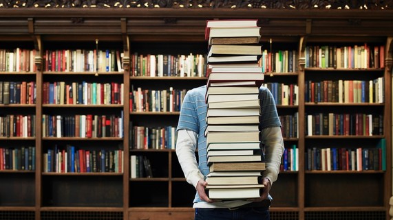 Person carries stack of books 