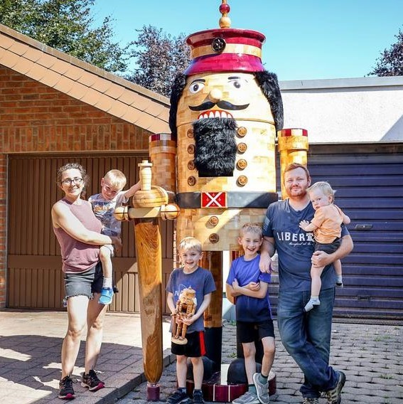John Miller, his wife, and kids stand next to the giant nutcracker Miller built.