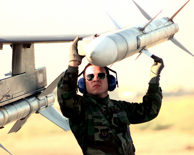 Senior Airman Huguet checks an AIM-120 AMRAAM on an F-16CJ Fighting Falcon.