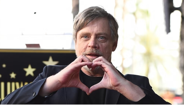 Mark Hamill makes a heart shape with his hands