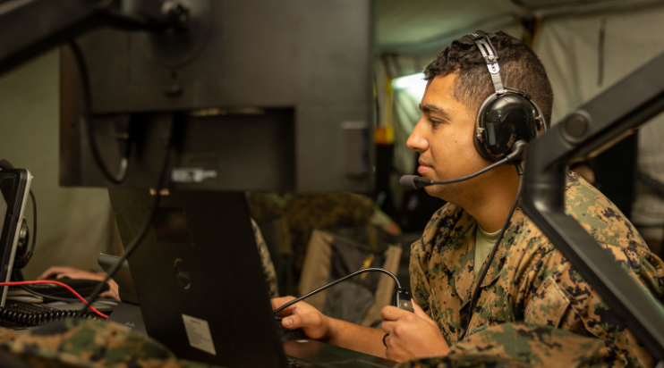 A Marine monitors his computer inside an expeditionary command and control (C2) node 