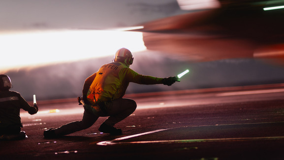 person with flight crouching near plane