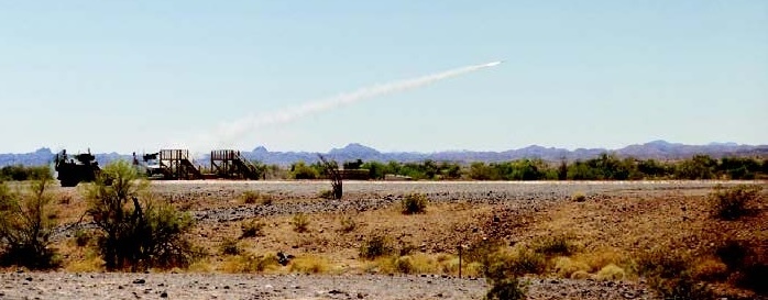 missile with vapor trailing launching in a brushy desert area
