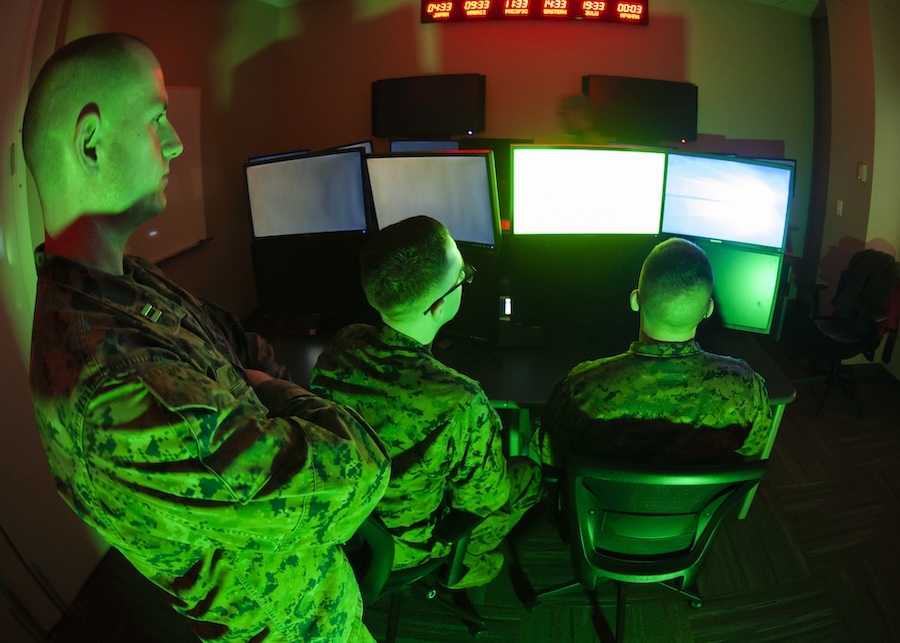 Marines looking at monitors in green light