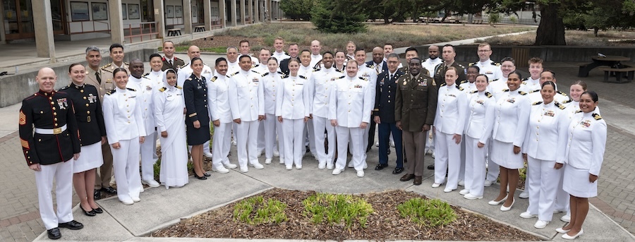 30-some men and women in dress uniforms posed in semi-circle 