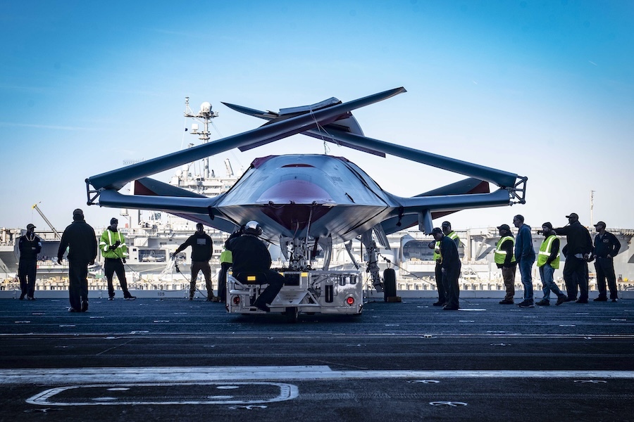unmanned aircraft on dock of aircraft carrier, workers other either side