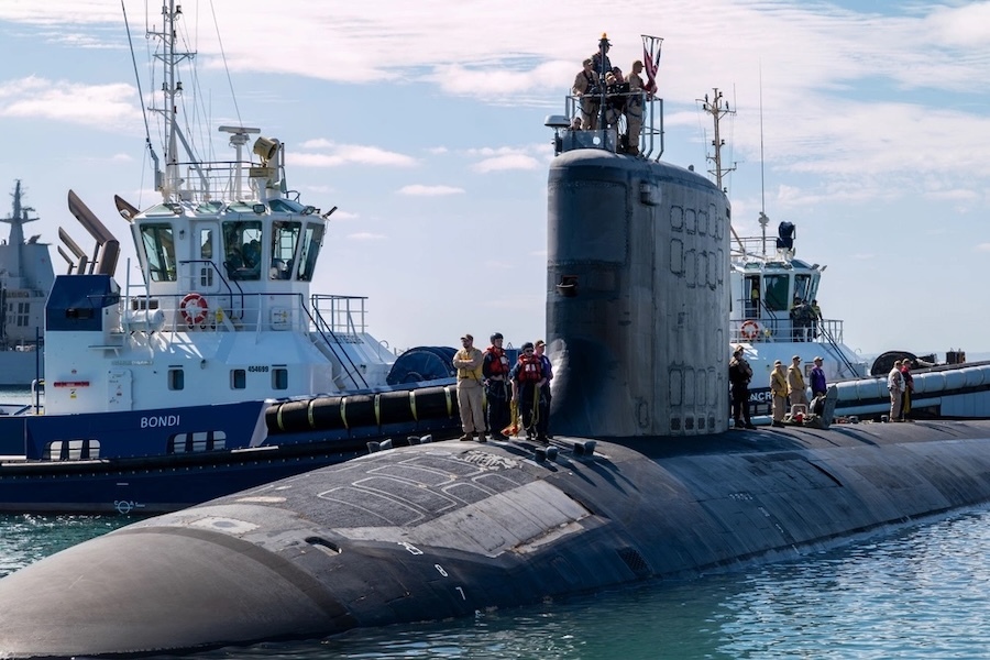 people standing on top of a surfaced submarine