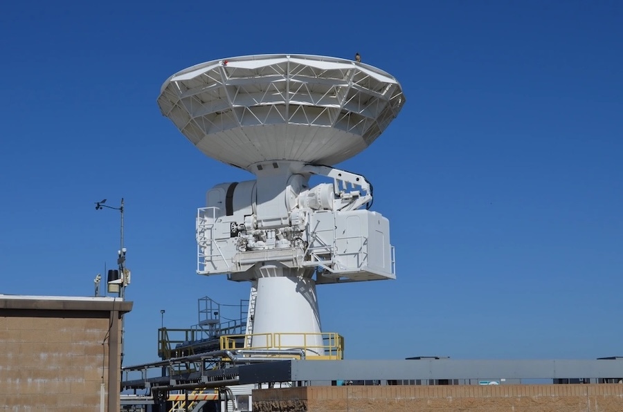 white radar dish against a blue sky