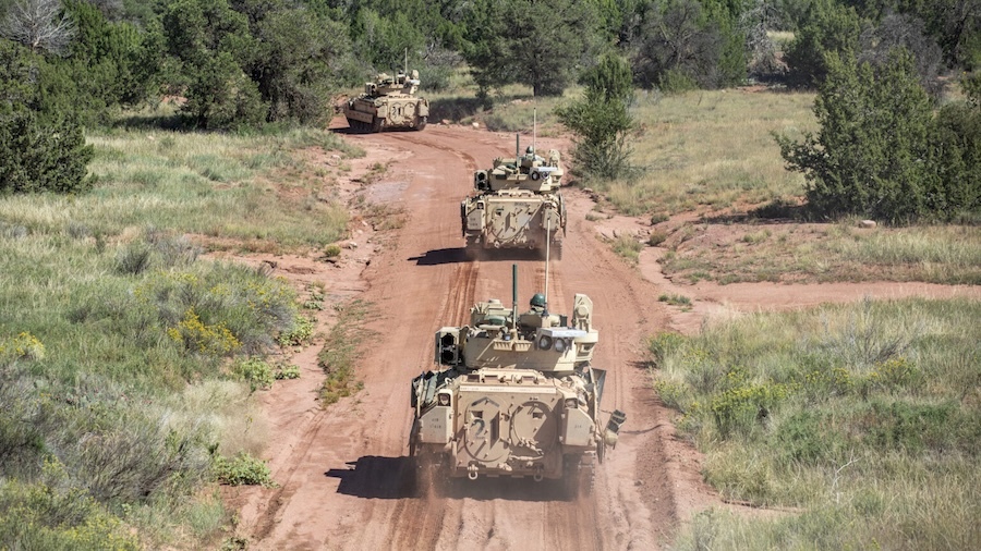 army vehicles on a red dirt road