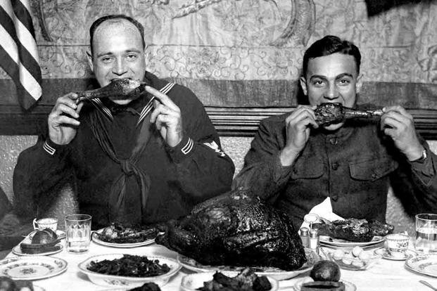 two sailors eating turkey legs