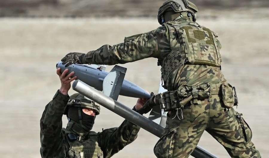 two soldiers in fatigues handling a drone