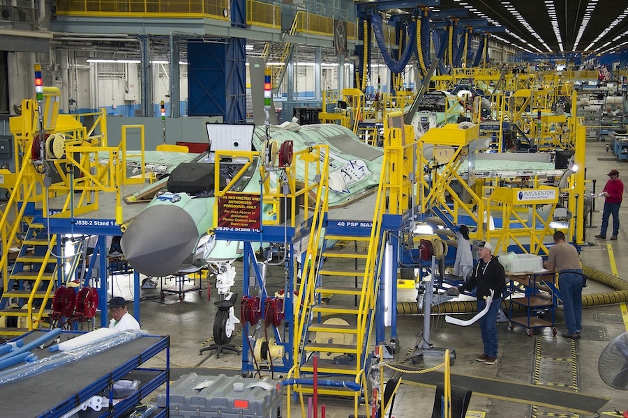 factory floor lined with planes surrounded by yellow stairs and platforms