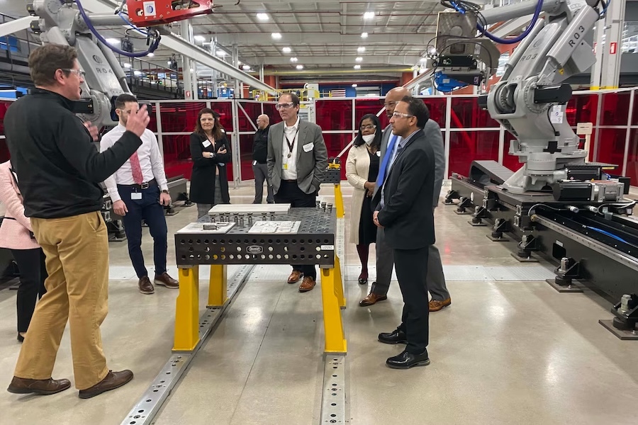 People standing around high-tech factory equipment