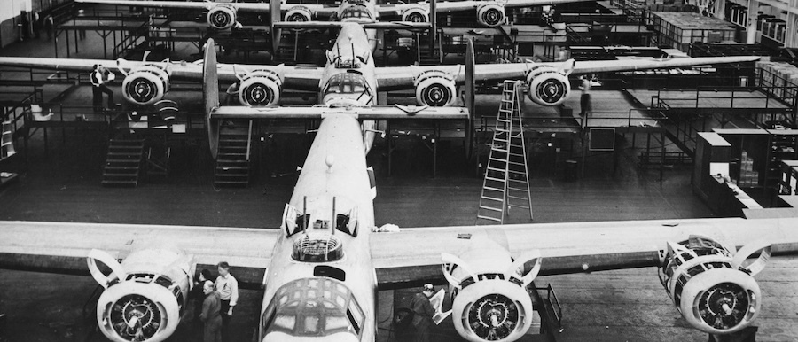 bw photo of planes lined upon a factory floor