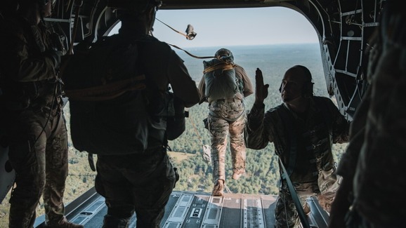 soldiers preparing to jump from the back of a plane