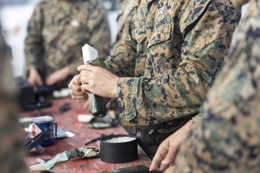 person in fatigues holding a block of C4