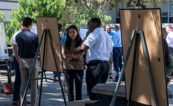 a crowd gathered around research posters