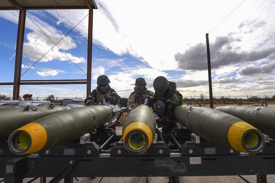 soldiers working over a row of bombs