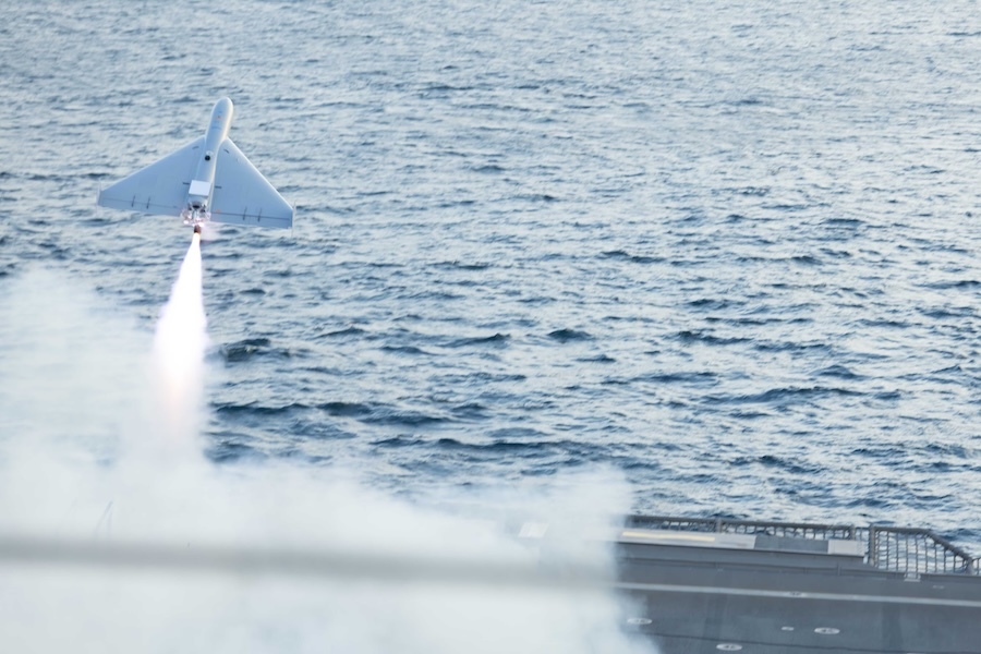 drone launches over water from the deck of a ship