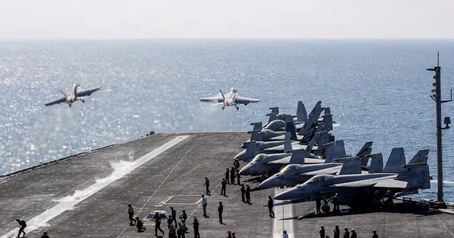 two planes take off from the deck of an aircraft carrier