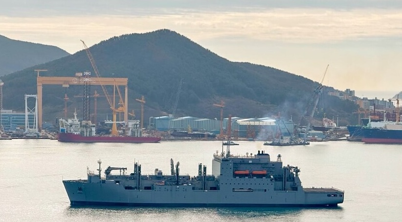 ship on water in front of shipyard