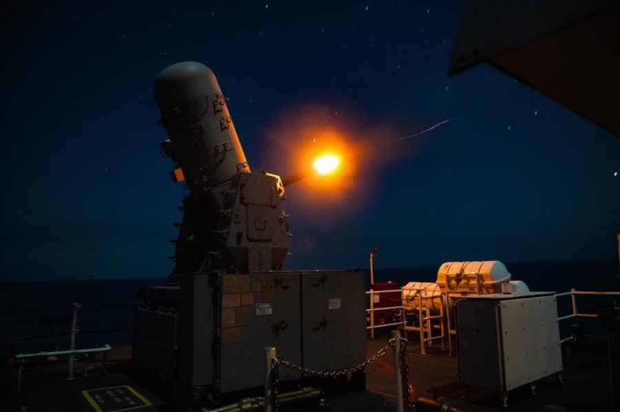 gun firing from the deck of a ship at night