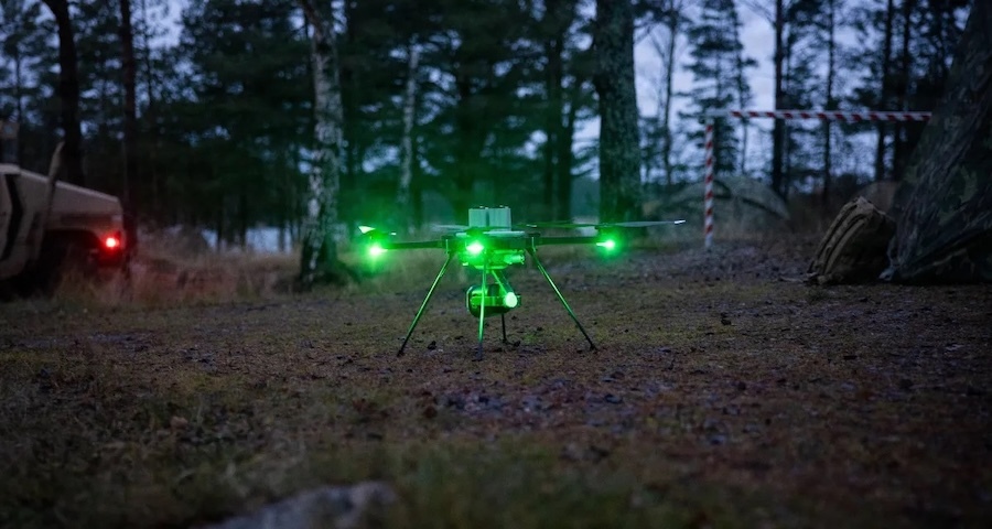 drone with green lights sitting on ground at dusk