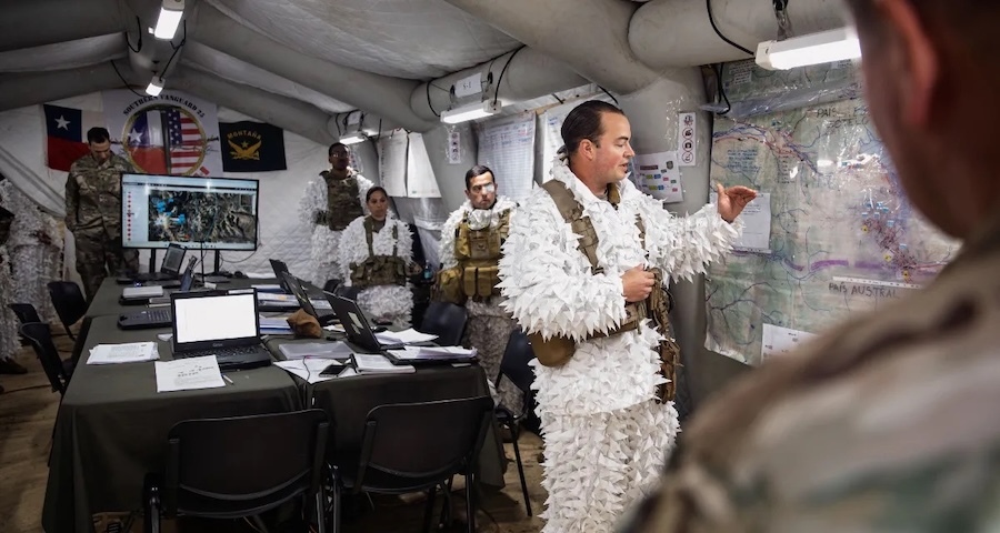 soldiers in white camouflage review a map