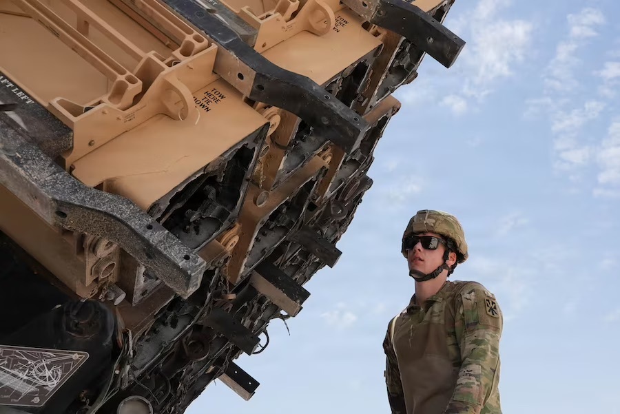 man in fatigues and helmet inspects machinery