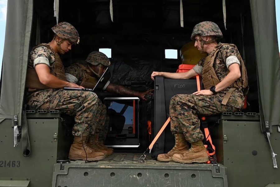marines in fatiques ride in the back of a truck