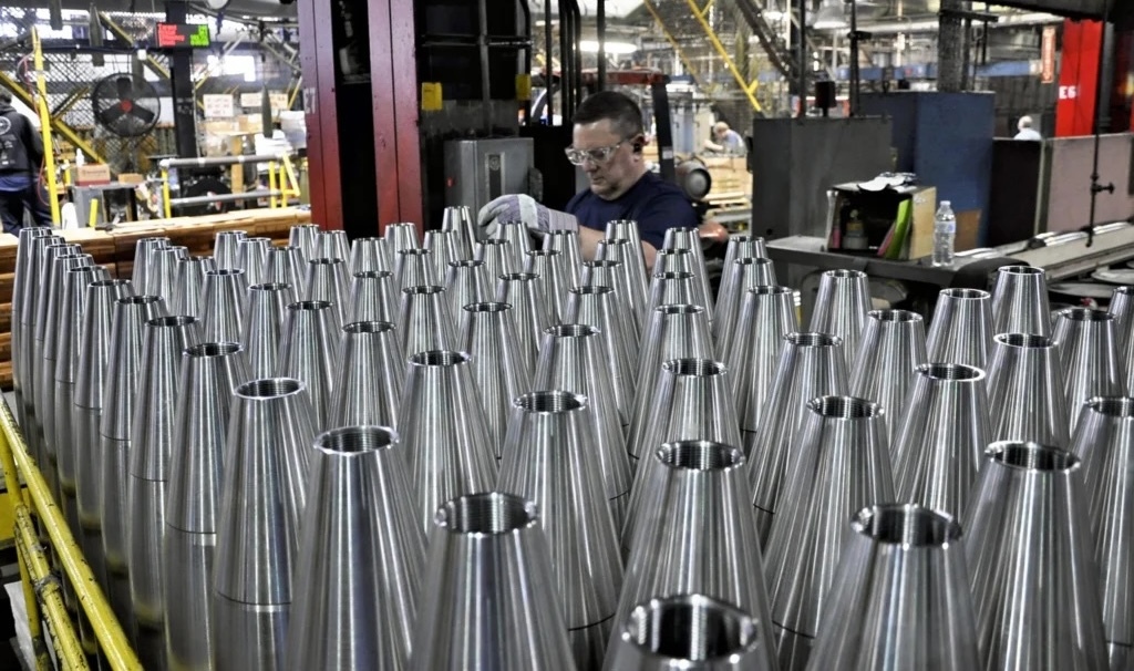 man inspects rows of artillery projectiles