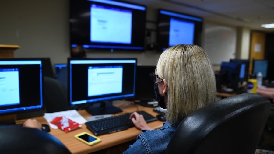 women seated in front of computer monitors